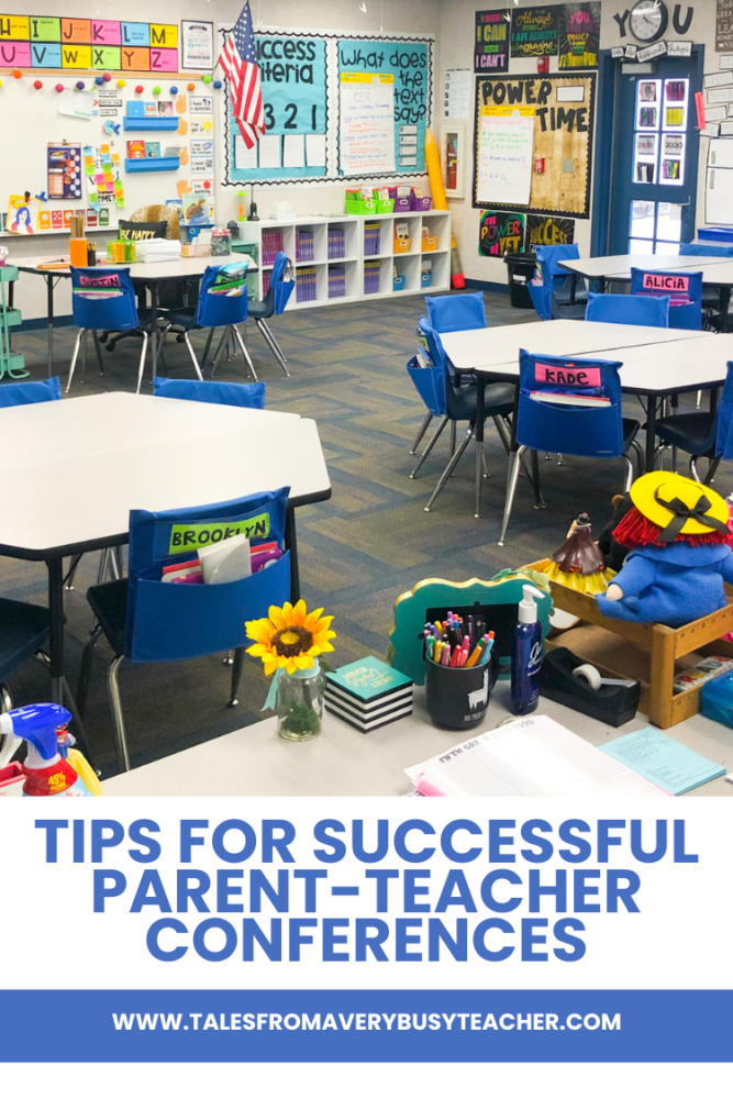 The image features a well-organized elementary classroom with multiple round tables and blue student chairs, each with pockets labeled with students' names. In the background, the walls display various educational posters and resources, including a prominently featured "Success Criteria" chart and "What does the text say?" anchor chart. The space is bright and engaging, with a focus on learning goals and classroom organization. On the teacher's desk, there are colorful supplies, including a vase with a sunflower, a pen holder, and books. The bottom section of the image features the text "Tips for Successful Parent-Teacher Conferences" along with the website "www.talesfromaverybusyteacher.com."